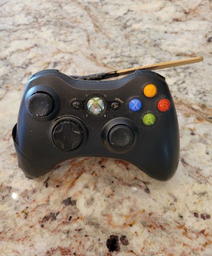 Le contrôleur Xbox 360 de mon frère a été modifié avec un bâton de popsicle, pour me permettre d'utiliser les déclencheurs plus facilement.